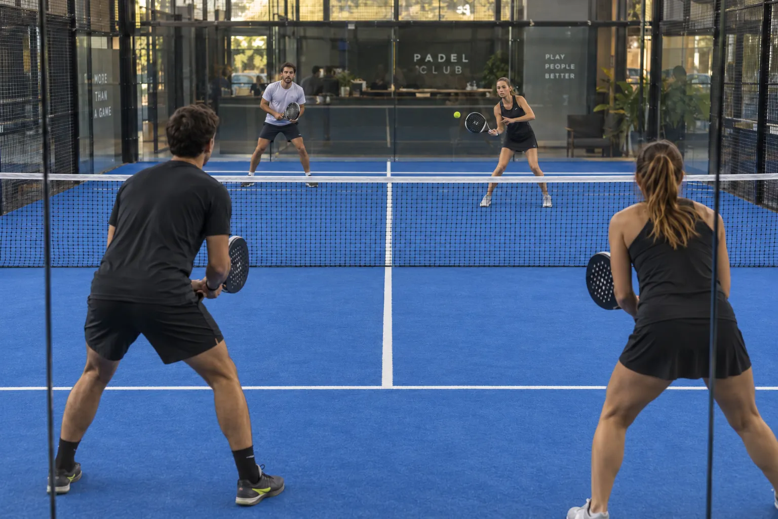 Vier Personen spielen gemeinsam Padel