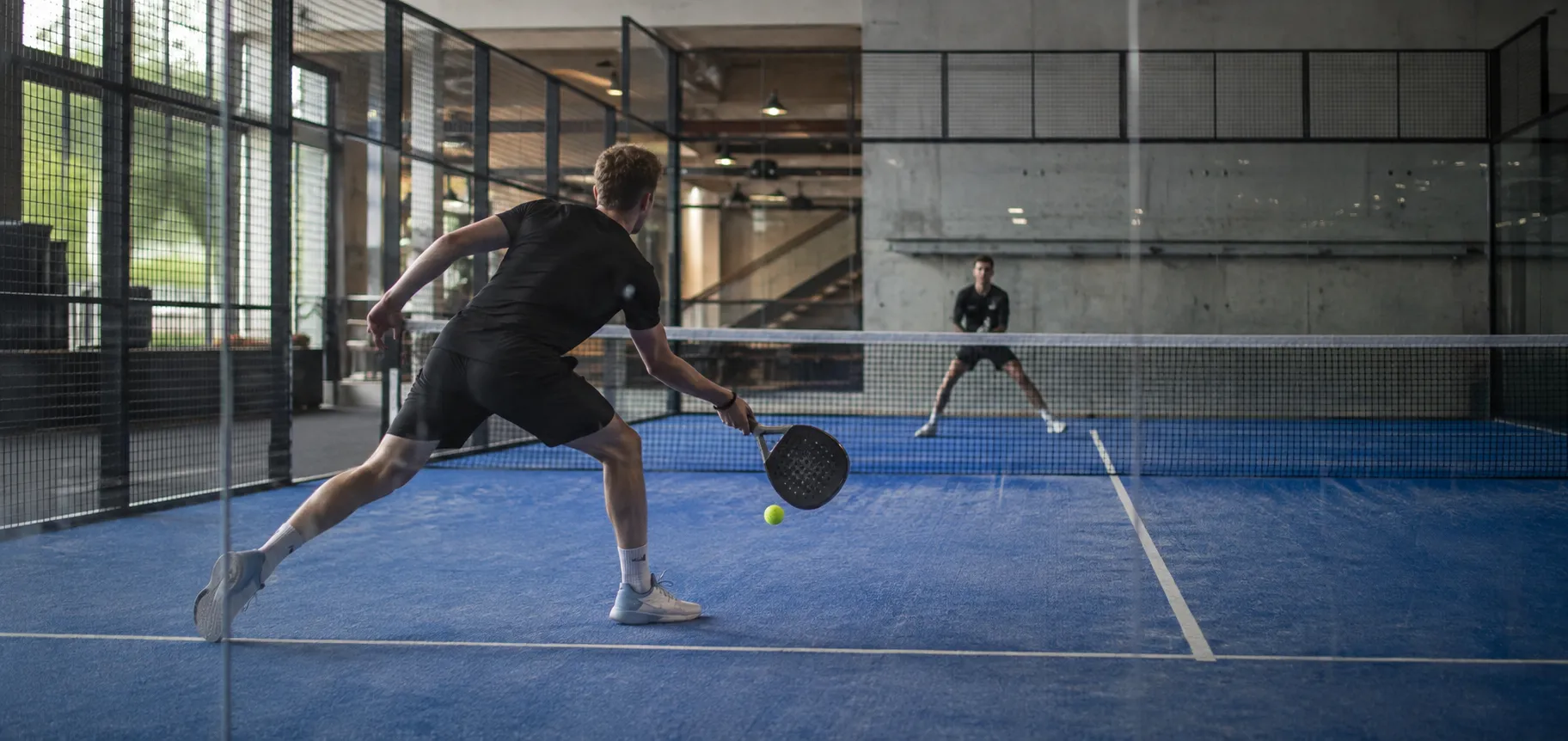 Symbolisches Padelspiel mit zwei Spielern in einer Halle